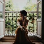 woman sitting on floor near window at daytime