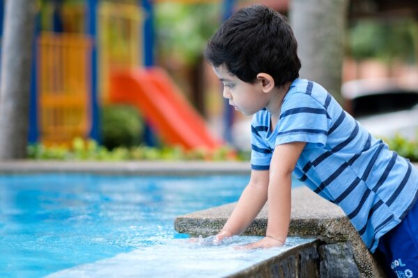 boy in blue and white striped shirt sitting on concrete bench