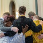 a group of people hugging each other in a church