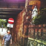 man in blue t-shirt standing beside red and white stop sign