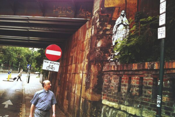 man in blue t-shirt standing beside red and white stop sign