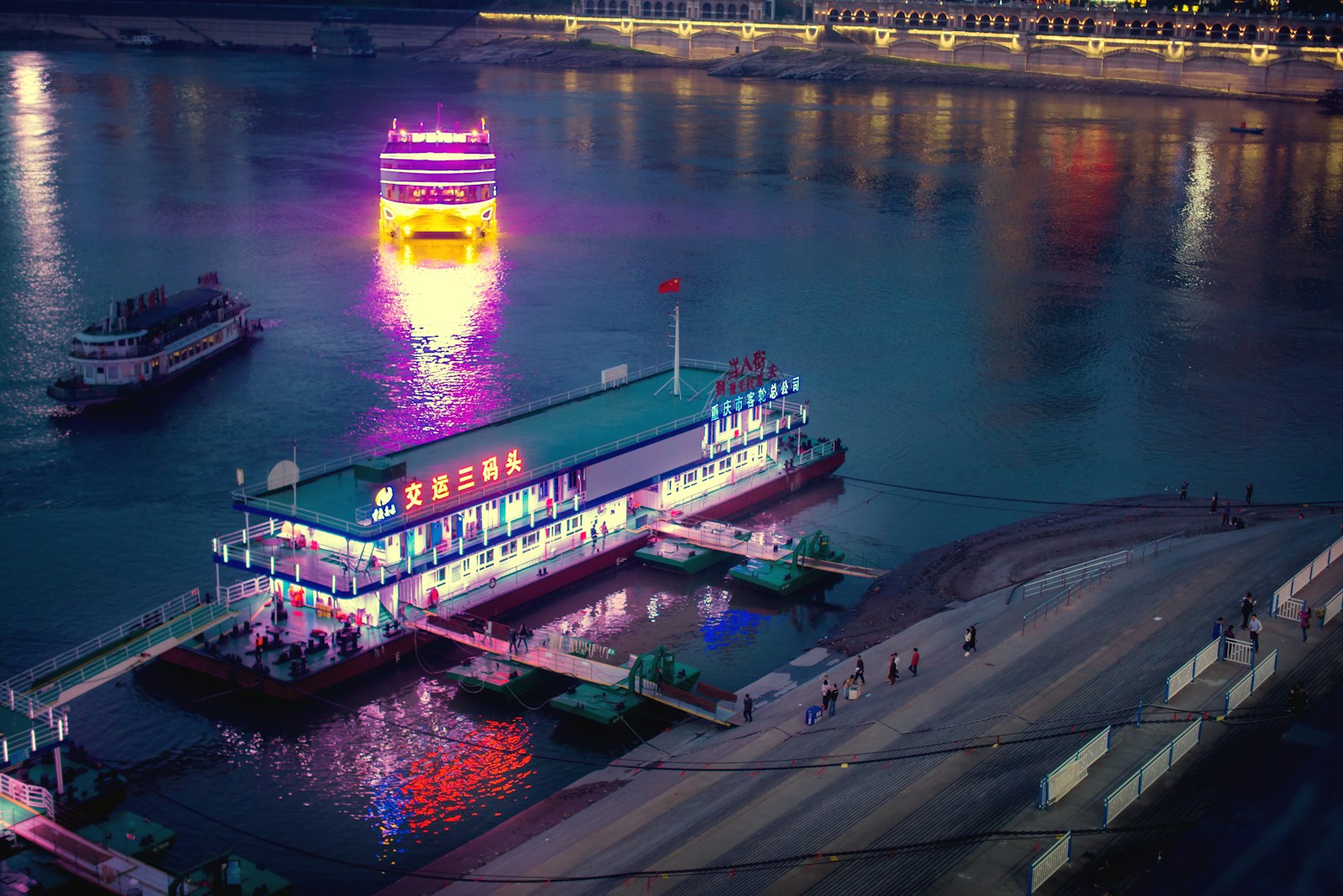 a large boat floating on top of a river next to a pier