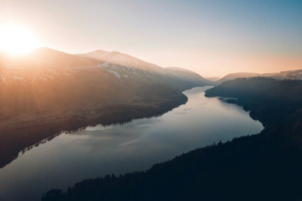 lake between trees and mountains