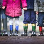 four children standing on dirt during daytime