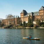 a person in a kayak in front of a large building