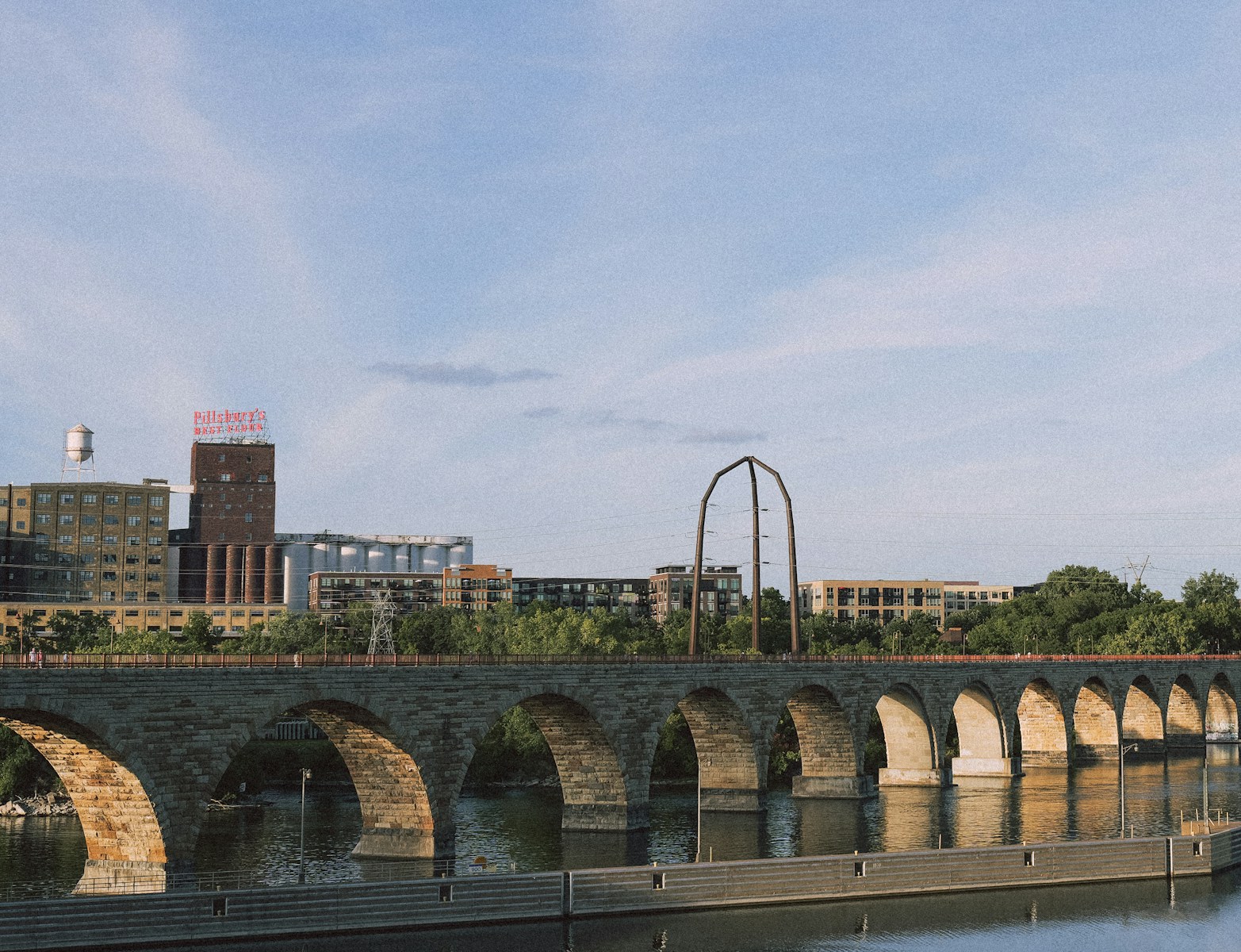 a bridge over a body of water with buildings in the background