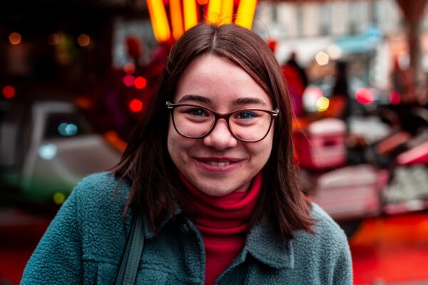 smiling woman wearing eyeglasses and green jacket