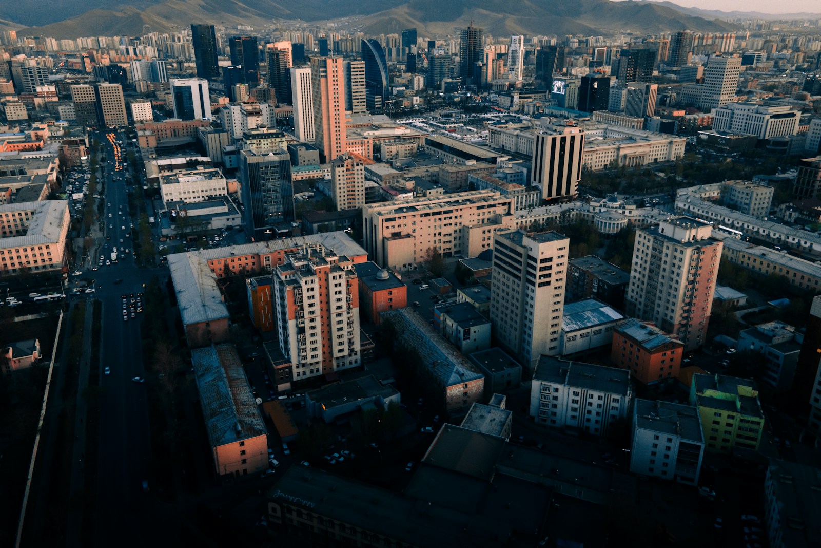 an aerial view of a city with mountains in the background