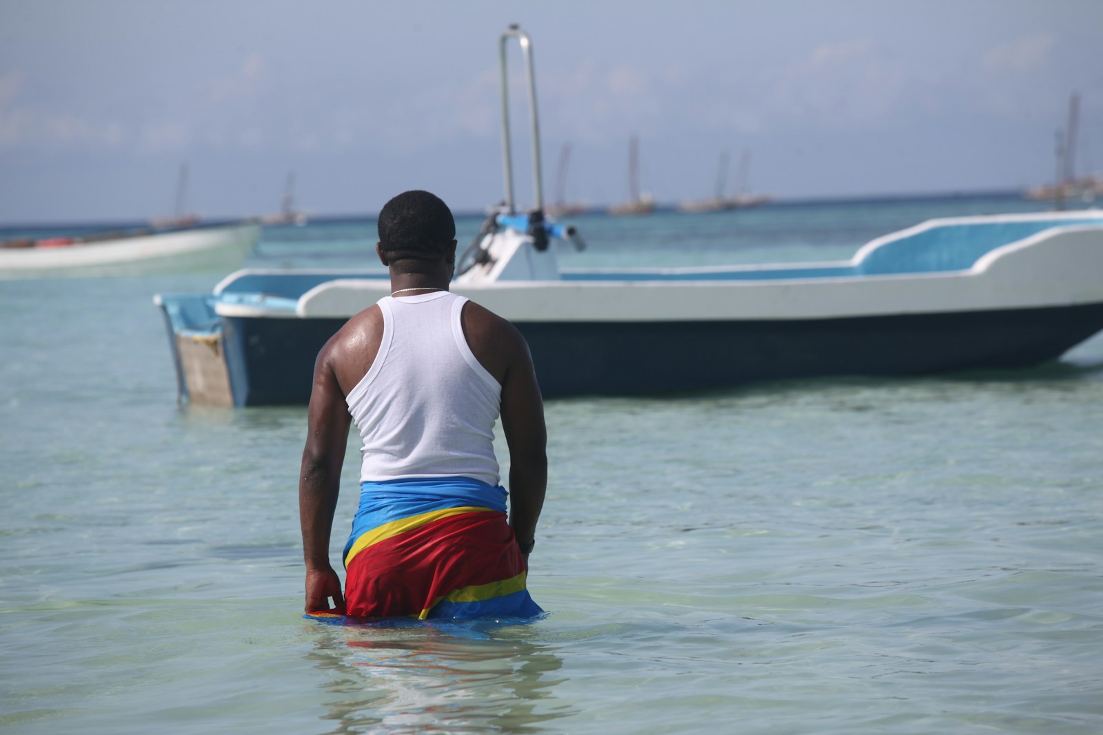 a man standing in the water near a boat