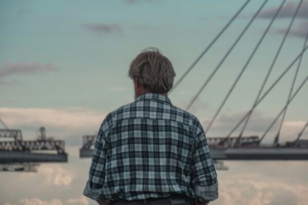 a man standing in front of a body of water