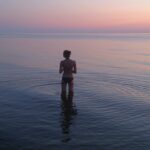 woman standing on body of water