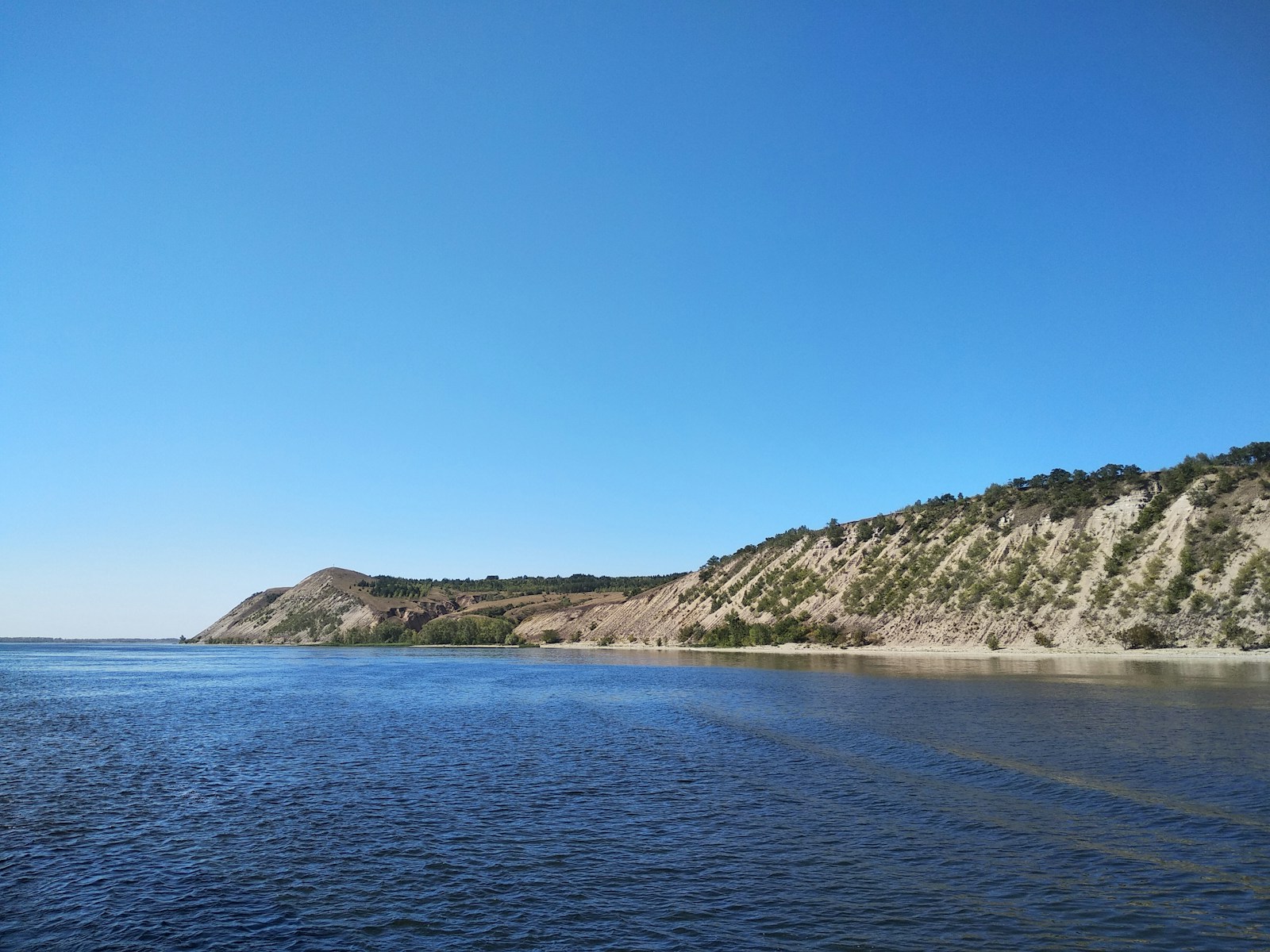 a body of water with a hill in the background