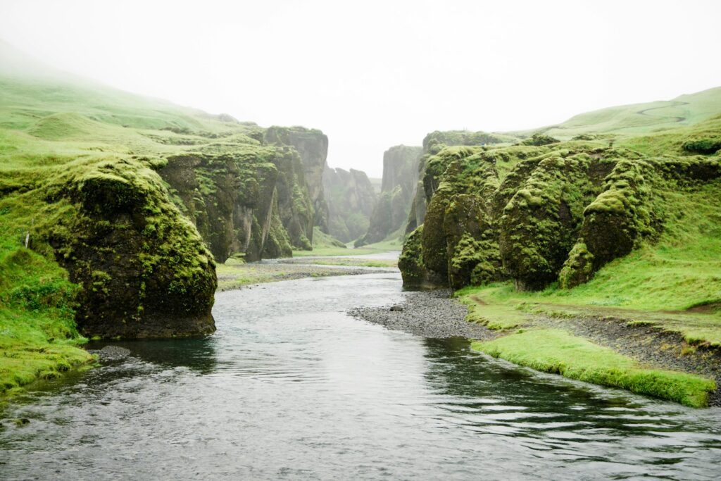 landscape photography of river between green mountains