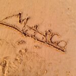 a word written in the sand on a beach