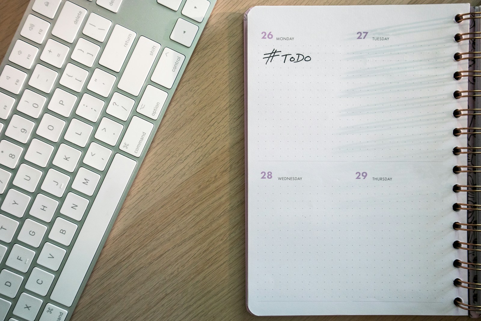 a notepad and a keyboard on a desk