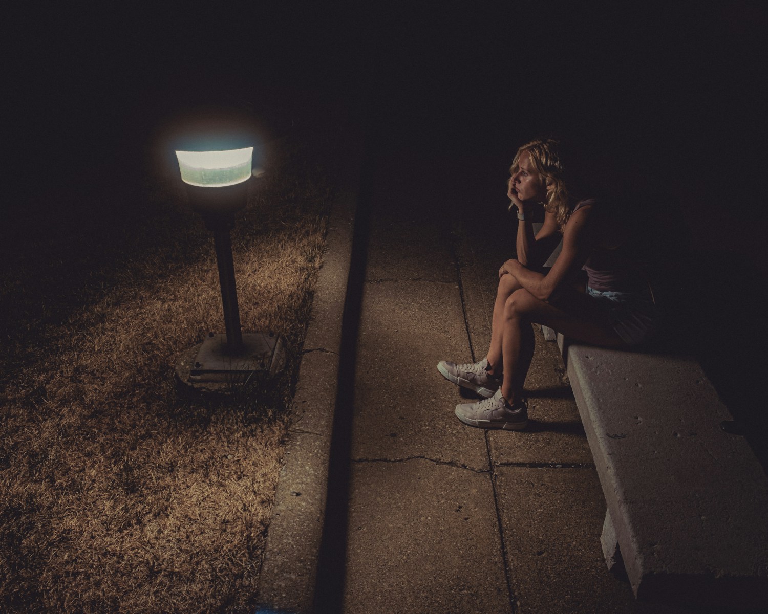 woman in black tank top sitting on concrete floor