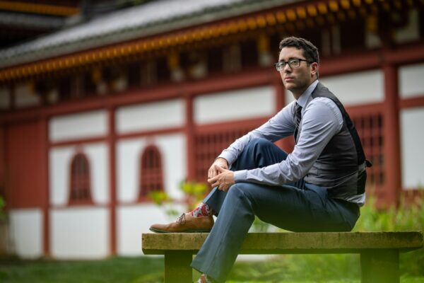 a man sitting on a bench in front of a building