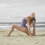 woman doing ballet stunt on beach shore