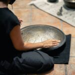 man in black t-shirt and black pants sitting on floor