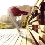 woman bending her body while holding metal bar