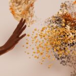 a hand reaching for a pile of seeds