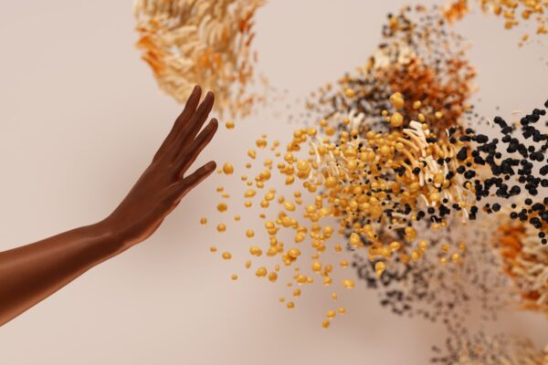 a hand reaching for a pile of seeds