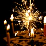 close up photography of sparkler beside candles