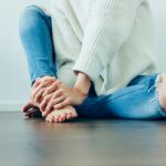 person wearing distressed blue denim jeans inside room