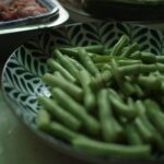green beans on white and blue floral ceramic plate