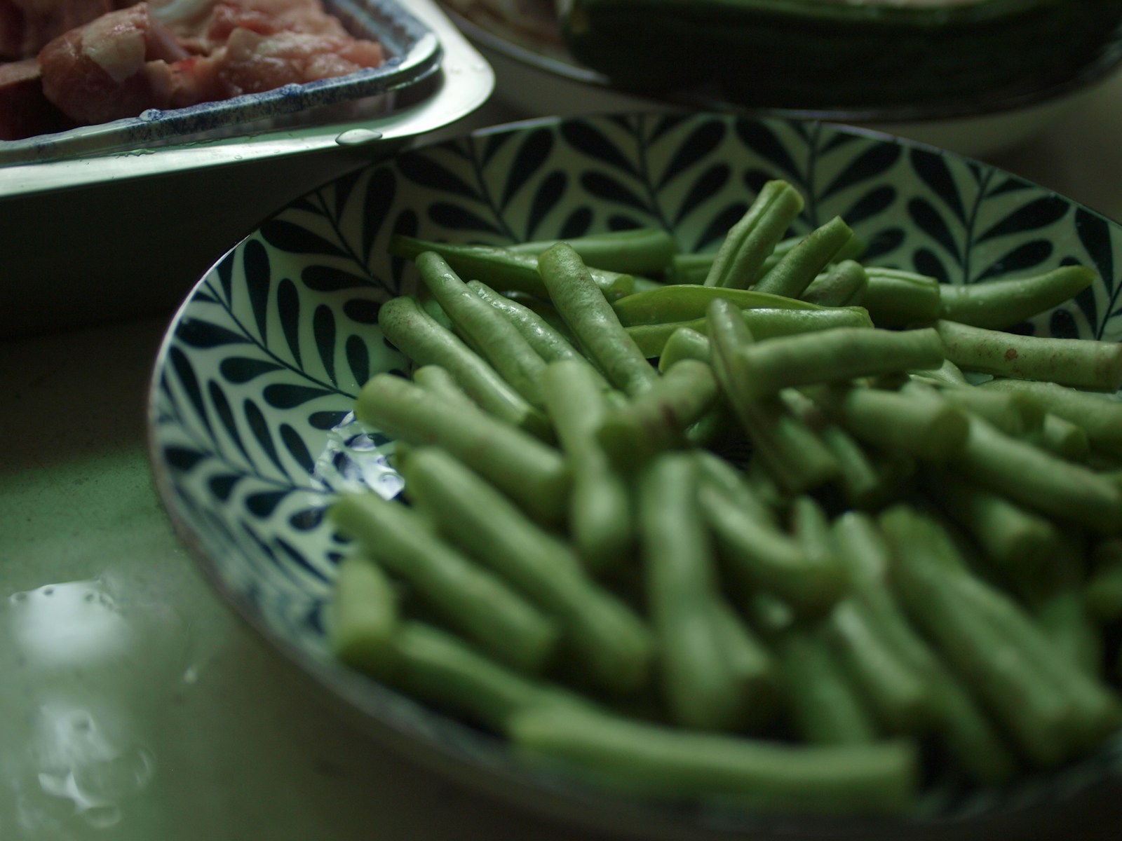 green beans on white and blue floral ceramic plate