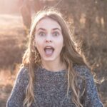 woman standing showing shocking face