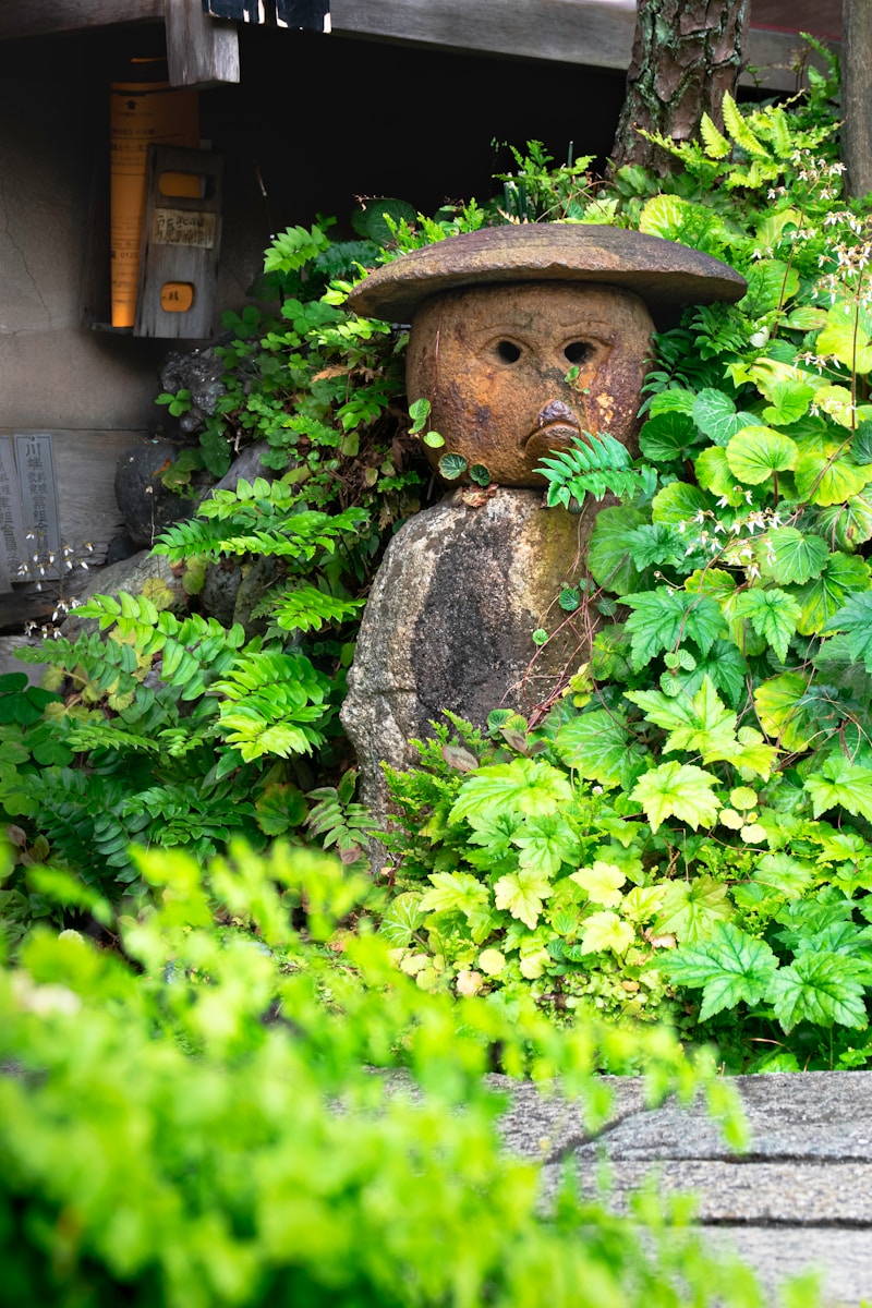 a statue of a bear in a bush with a hat on