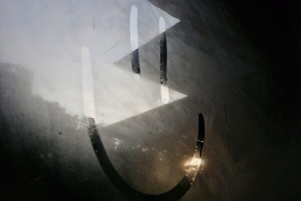 A smiley face is drawn on a foggy surface.
