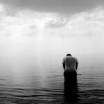 grayscale photography of person on beach