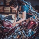 photo of woman repairing motorcycle